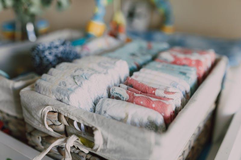 Couches bébé rangées dans un panier en osier — cadeau de naissance utile et écologique
