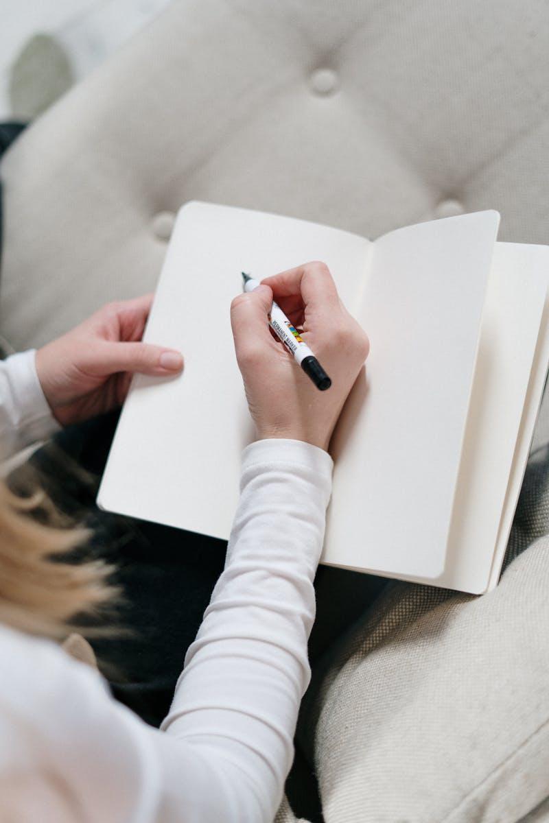 Personne écrivant dans un journal ouvert — livre de naissance pour bébé