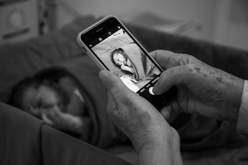 Grand-parent photographiant son petit-enfant nouveau-né — le meilleur cadeau de naissance